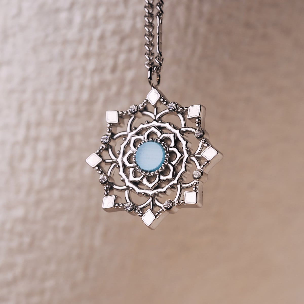 "Aphonia Necklace" necklace, featuring intricate silver design with aquamarine center.