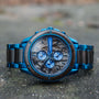 "Priamus" watch in maple and marble, featuring a striking blue design and intricate dial details.