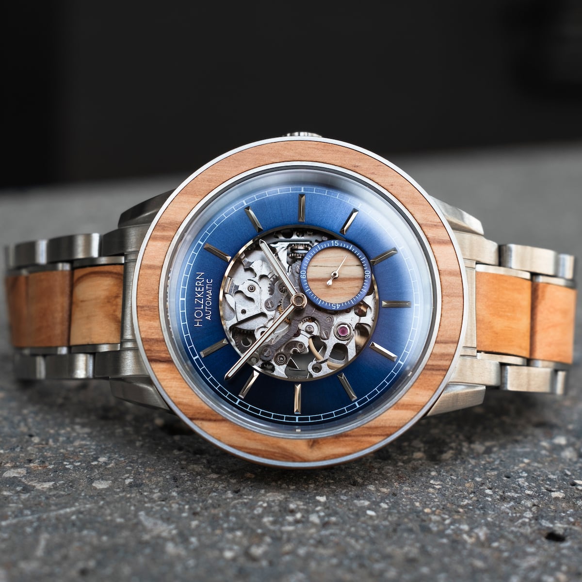 "Haiku" watch, featuring an olive-toned design with a metal band and intricate skeletal dial.