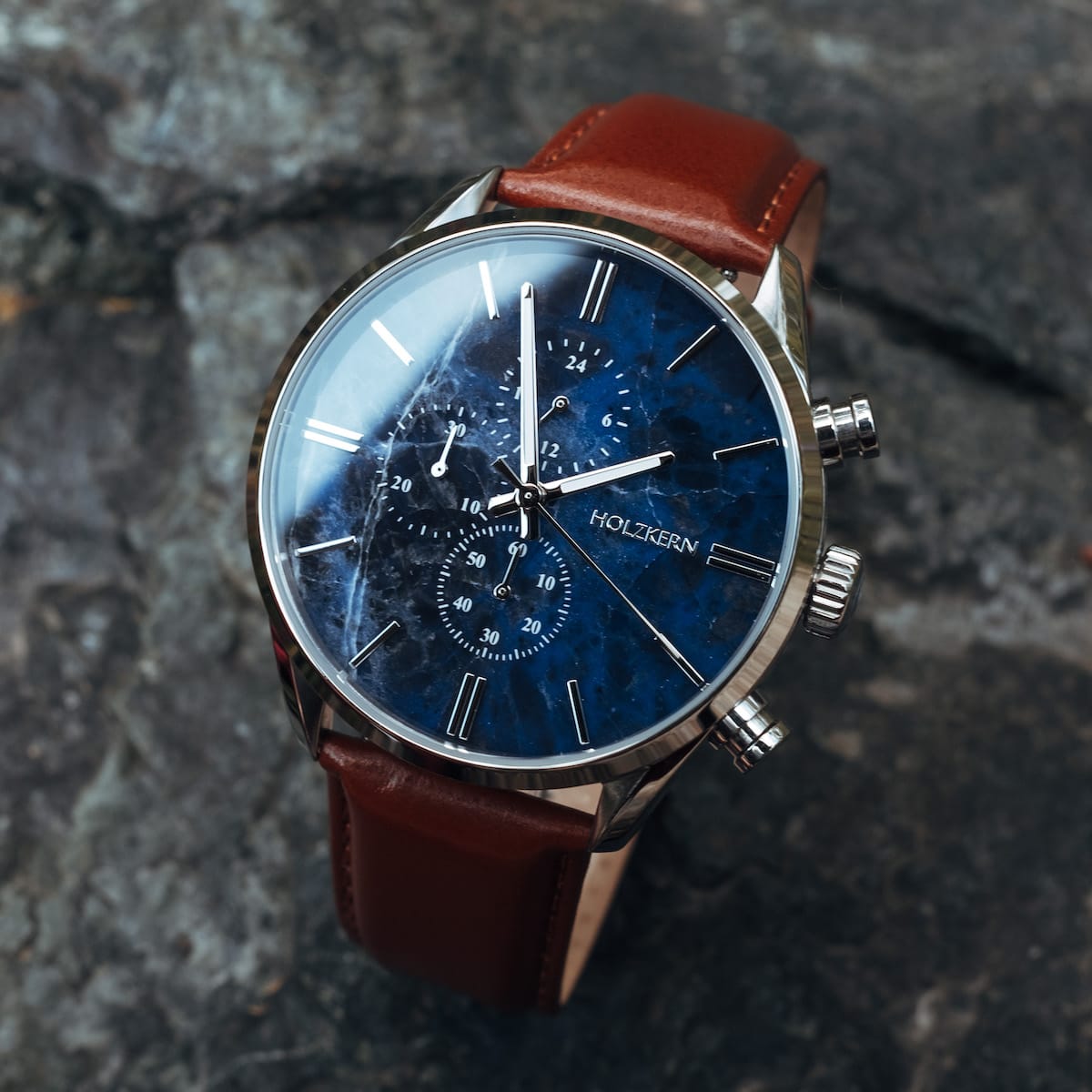 "Naturalist" watch featuring a marble-style blue face with silver accents and a brown leather strap.