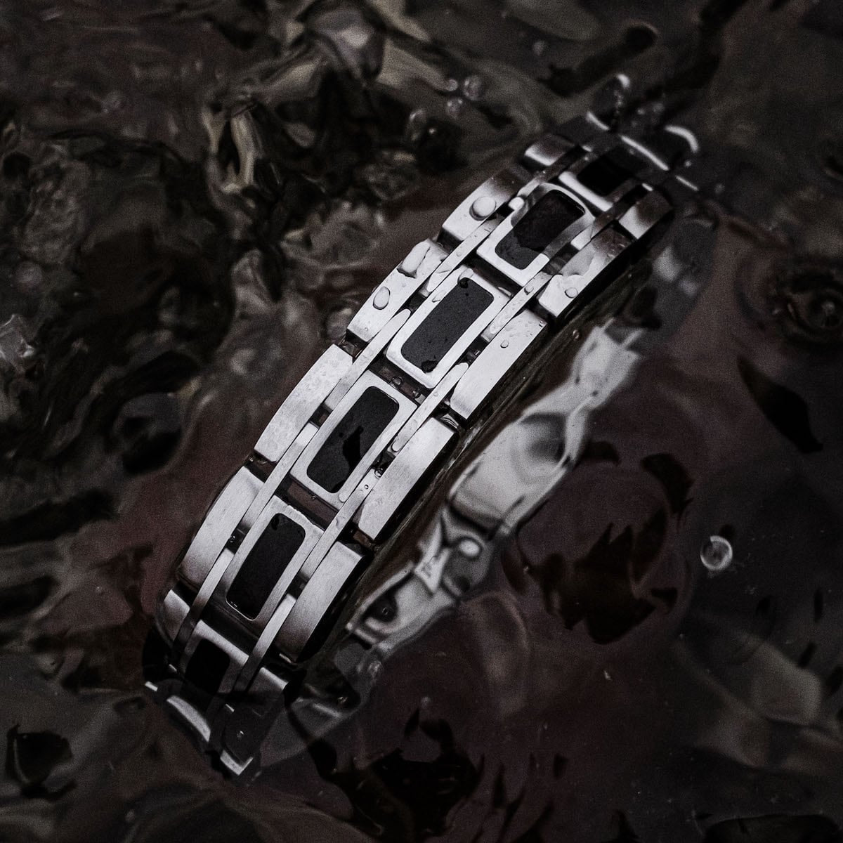 "Tremolo", a stylish bracelet in maple and silver, showcased against a dark, textured background.