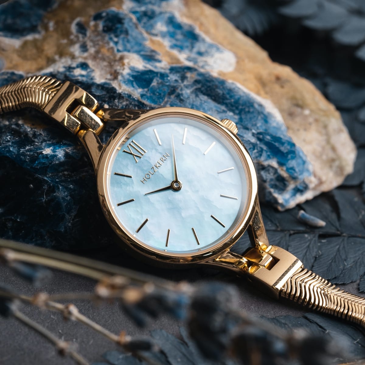 "Shesha", elegant wristwatch with nacre dial and gold accents, blends luxury with natural charm.
