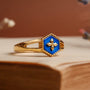 "Spectral Ring", a striking ring with blue nacre and gold, featuring a detailed hexagonal emblem.