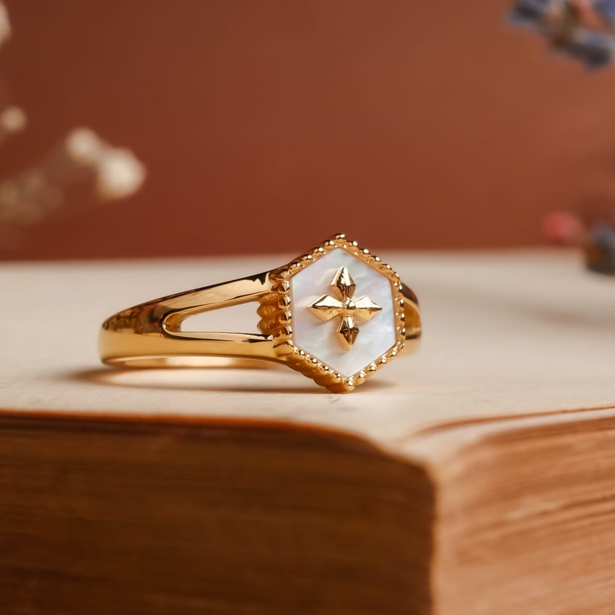 "Spectral Ring" ring featuring a white nacre centerpiece with gold accents, showcasing a stylish and elegant design.