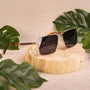 "The Talisman" sunglasses in walnut and matte gold with a stylish, modern design.