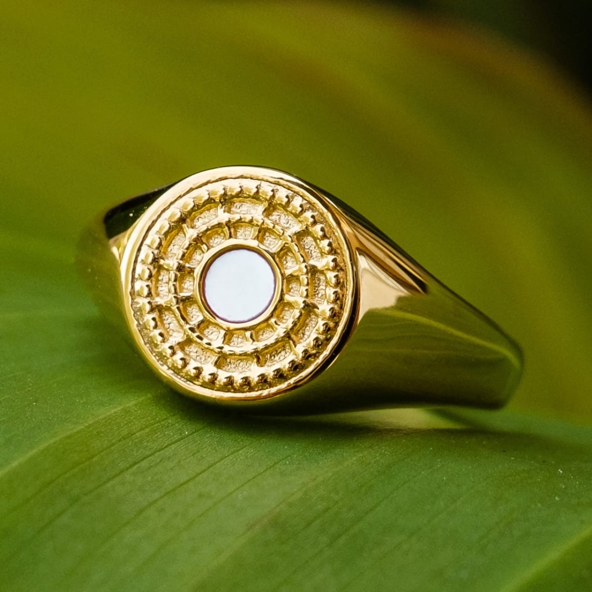 "Pixa Ring", a gold ring with white nacre, featuring a stylish and textured design.