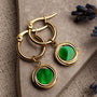 "Zendala Earrings" earrings, featuring green nacre and gold accents, with an elegant circular design.