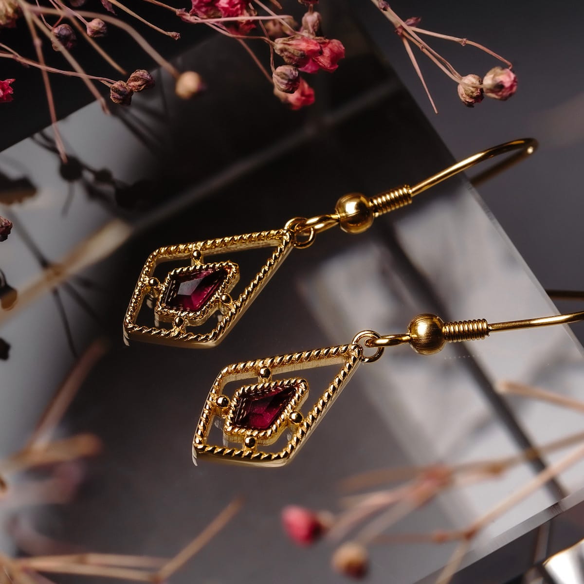Daydreamer earrings, elegant earrings with amethyst stones and gold finish, featuring a delicate and intricate geometric design.