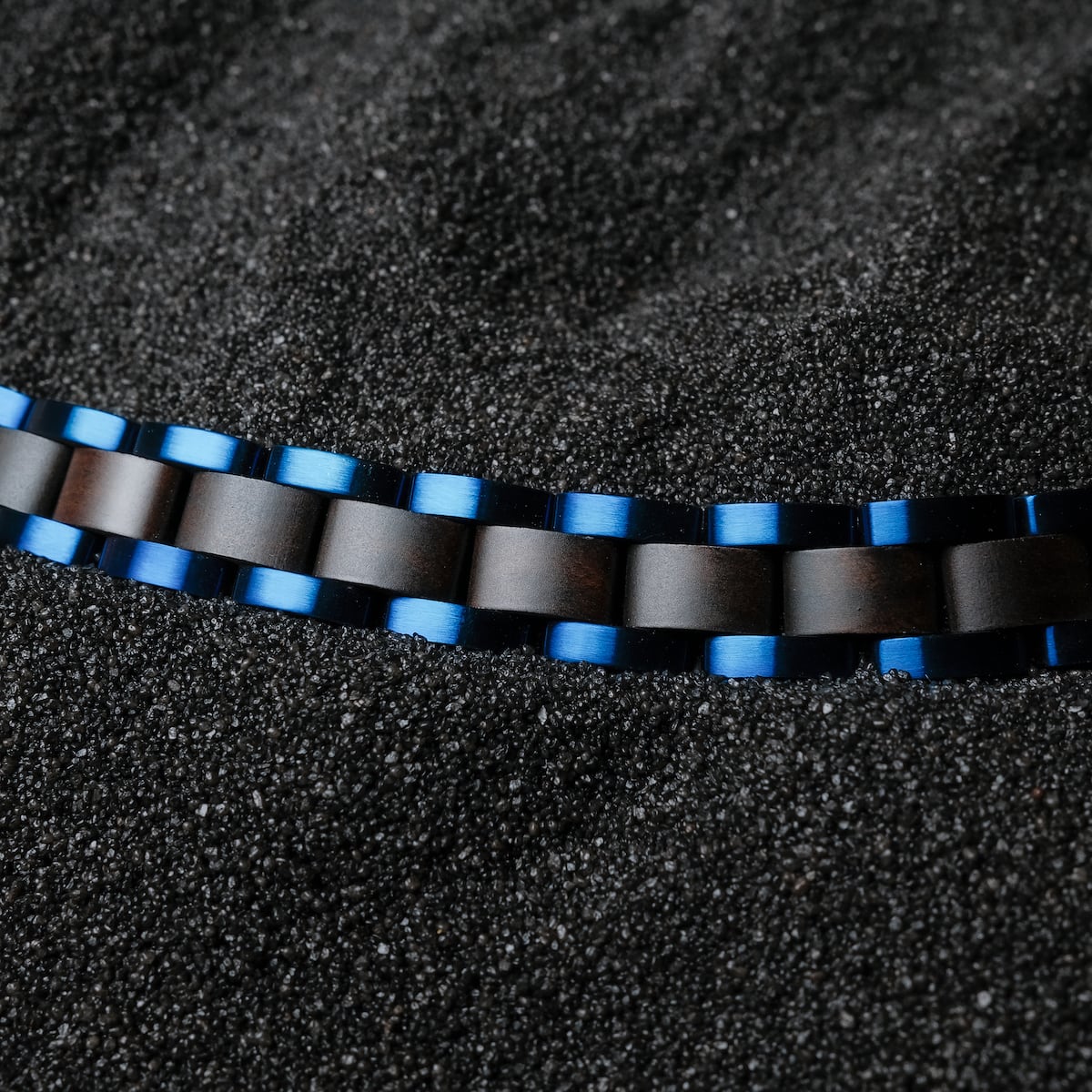 "Triad", a stylish bracelet featuring a maple and blue design against a textured black background.