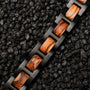 "Acoustic" watch band with zebrawood accents and black links on a textured dark background.