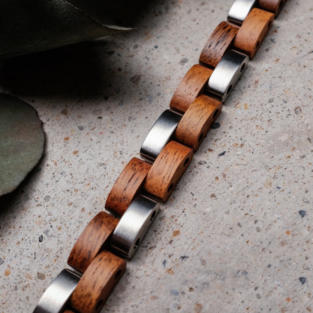 "Rondo" bracelet featuring koa wood and silver links, showcasing a natural and sleek design.