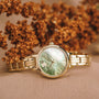 "Themis" watch, featuring a nacre dial and gold band, exudes elegance and luxury.