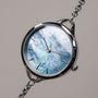 "Brighter" watch featuring a nacre-style dial and silver accents with a sleek, modern design.