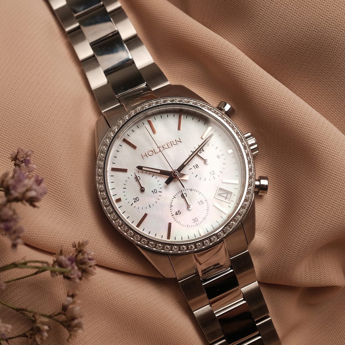 "The Balanced", a stylish watch featuring nacre and silver materials against a soft background.