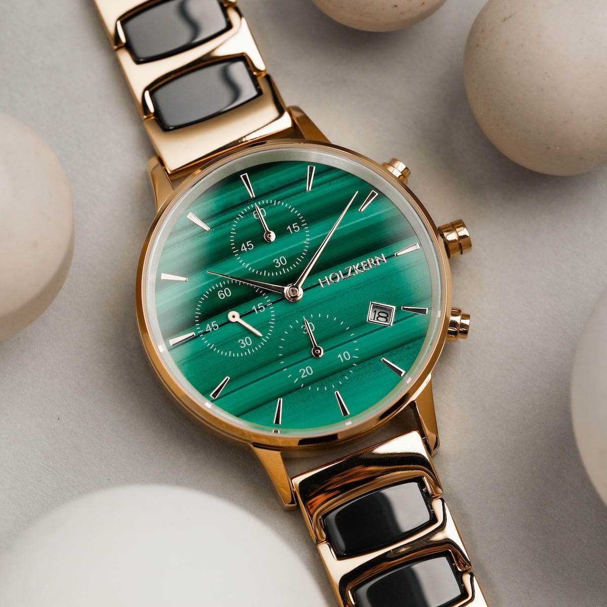 "Jolly" watch featuring a malachite green dial with a ceramic and gold-toned bracelet, elegant and modern style.