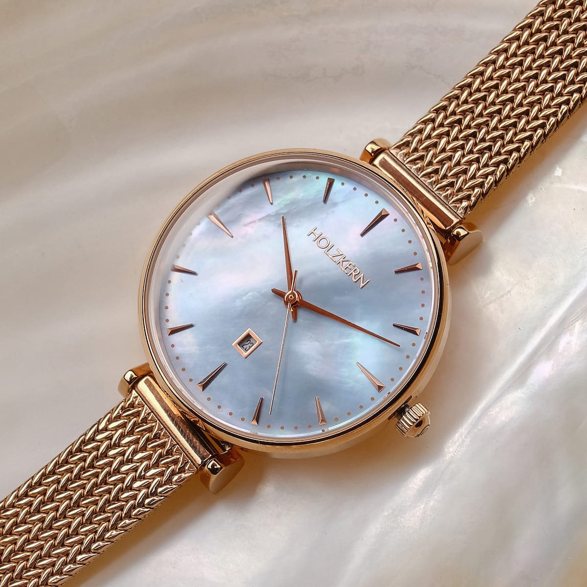 "Chitchat" watch featuring a nacre dial and rose gold mesh strap for a luxurious look.