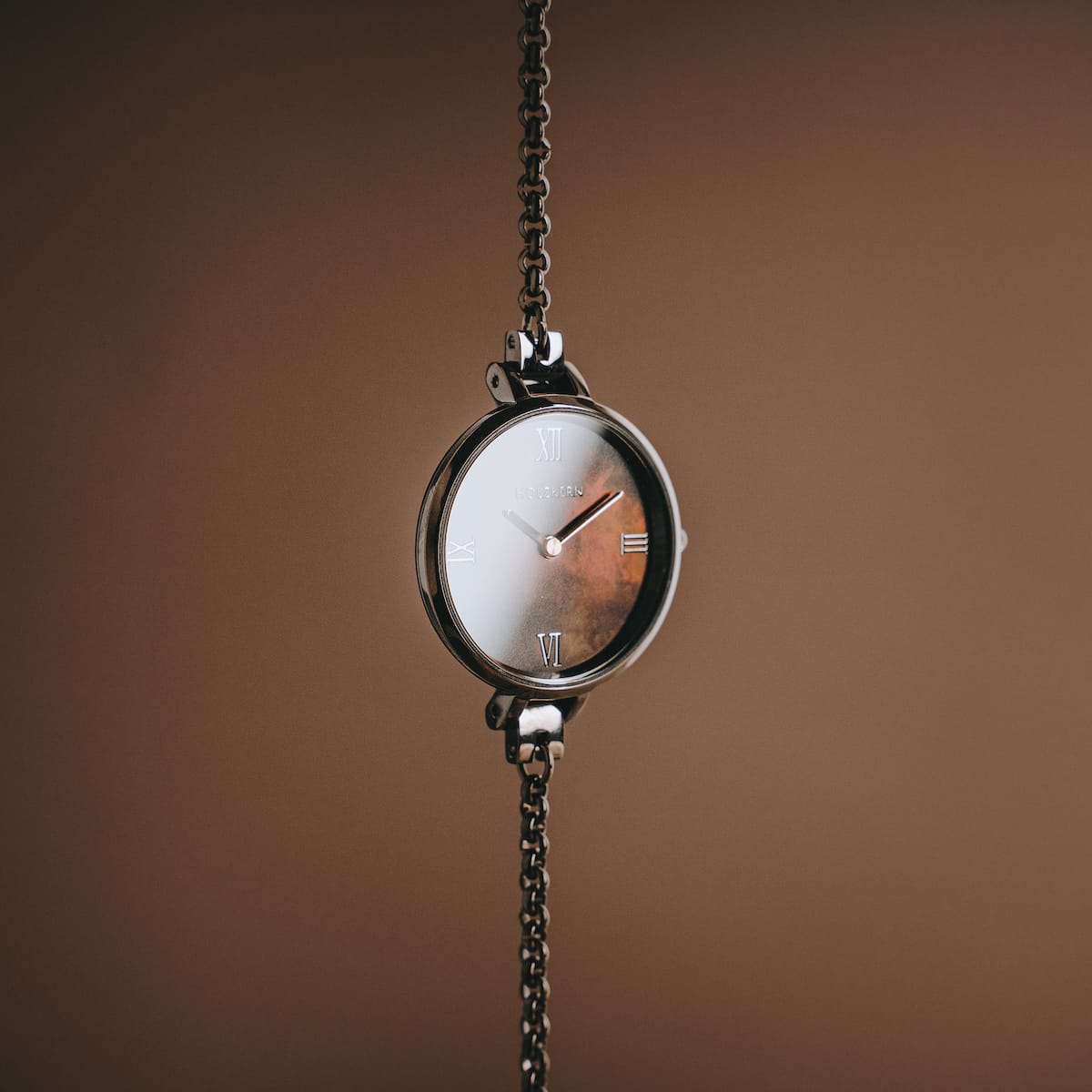 "Élisa" watch in nacre and dark gray, featuring a sleek chain and elegant design.