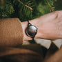 "Élisa", an elegant watch with a dark gray face and nacre accents, showcasing a timeless style on a wrist.