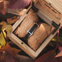 "Acapella" watch, featuring a leadwood and silver design, nestled in a rustic box with autumn leaves.