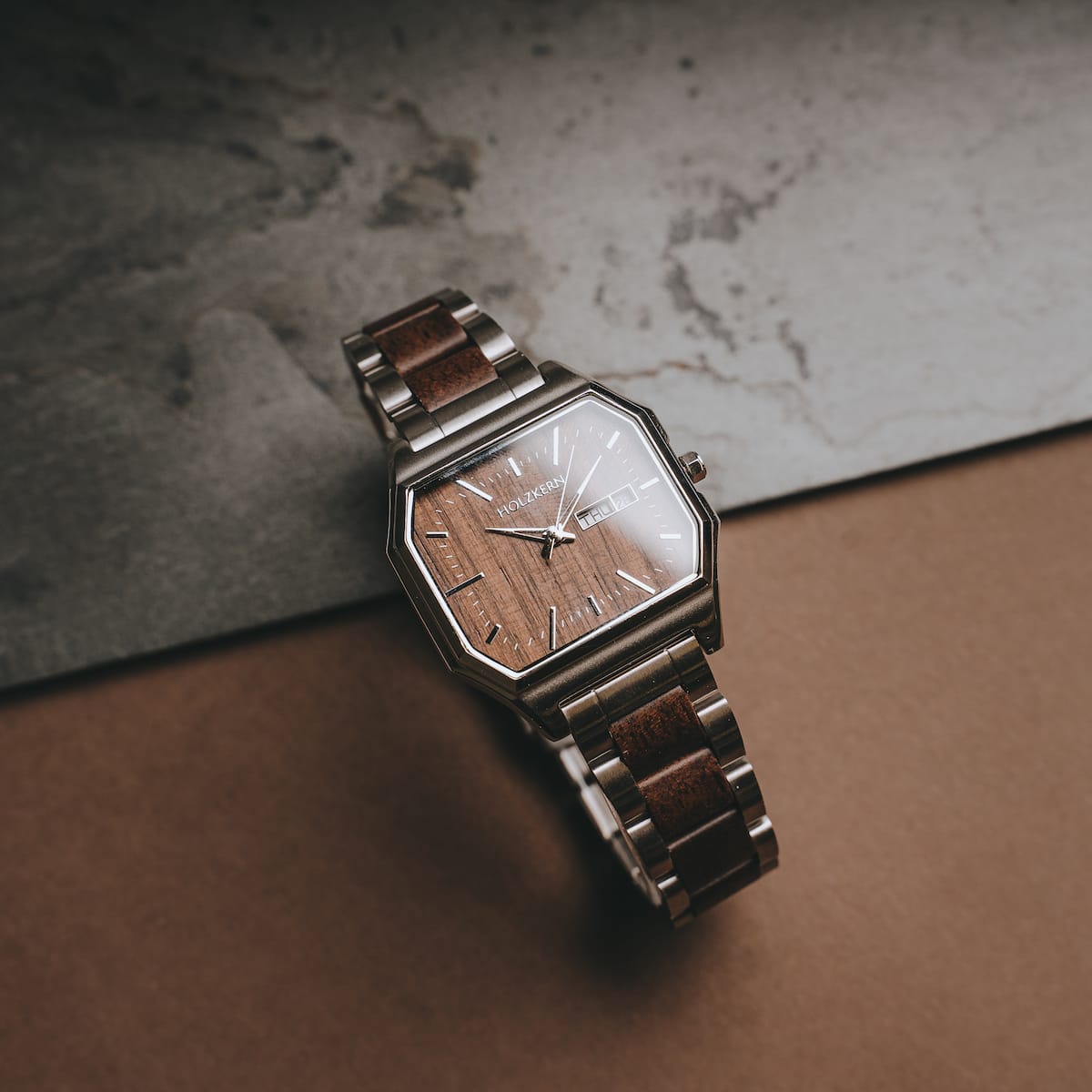 "Gaudí" watch with a walnut face and walnut accents, showcasing a sleek and elegant design.
