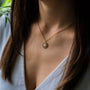 "Composition Necklace": a delicate necklace featuring a gold chain and blue nacre pendant, blending elegance with modern style.