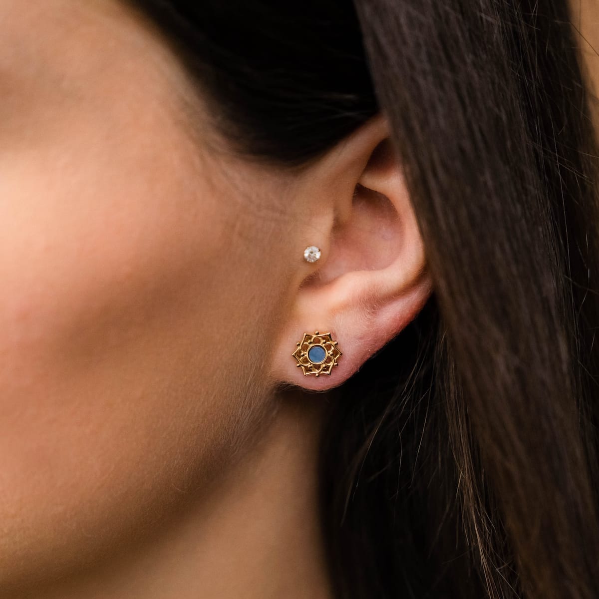 "Composition Earrings" earrings feature a blue nacre center with a gold intricate design, offering a touch of elegance and style.