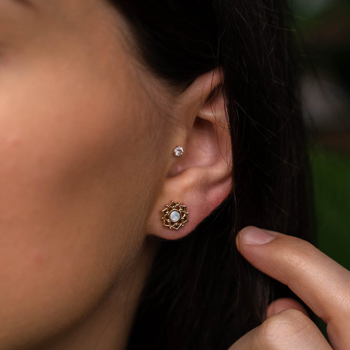 "Composition Earrings", elegant earrings featuring white nacre and gold, showcased on an ear with a delicate design.