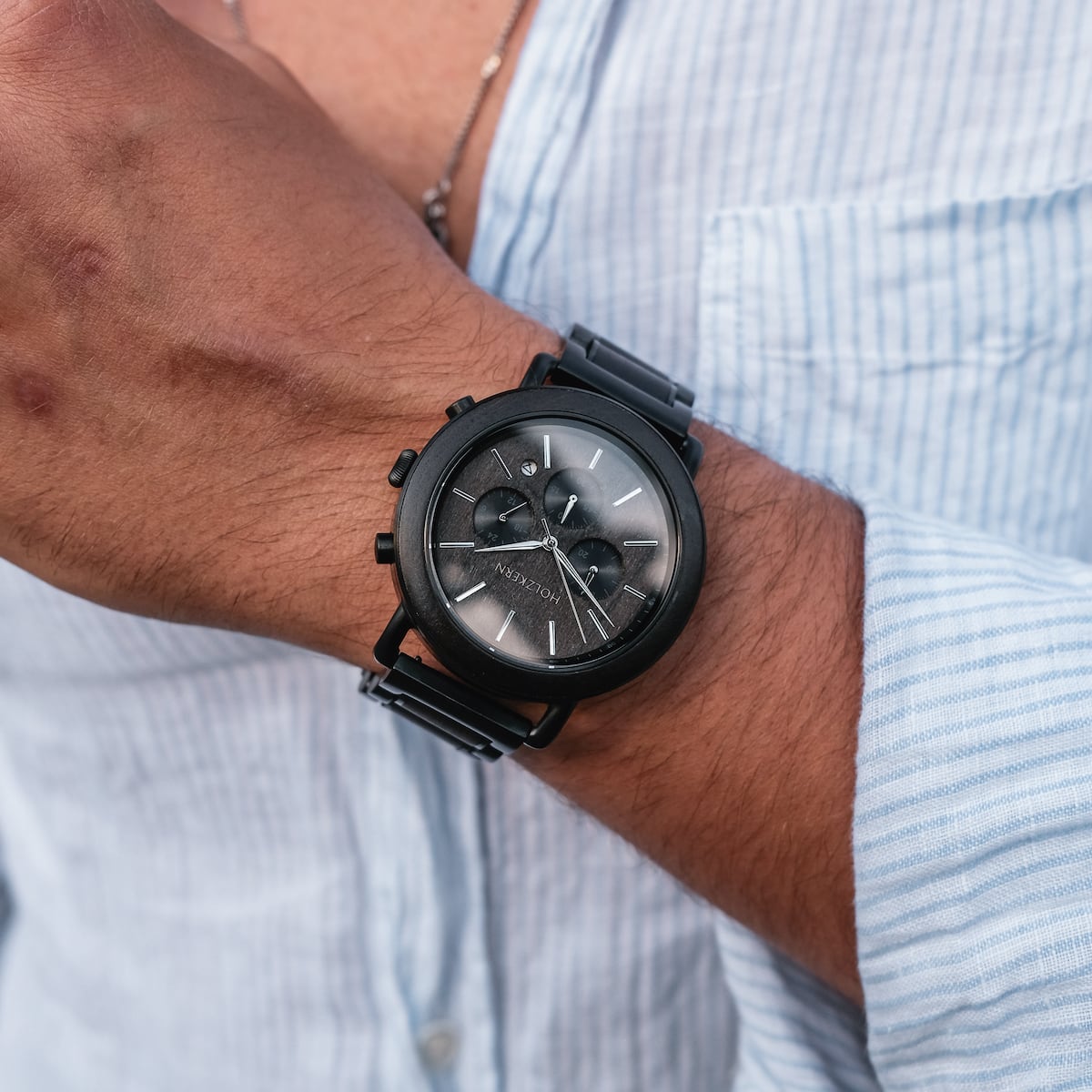 "Piton" watch, featuring a sleek black design and minimalist chronograph style on the wrist.