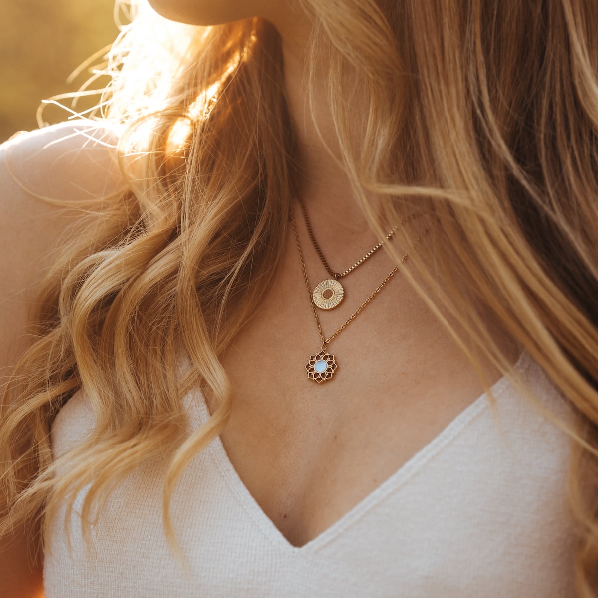 "Composition Necklace" necklace, featuring blue nacre and gold, elegantly layered on a woman's neckline.