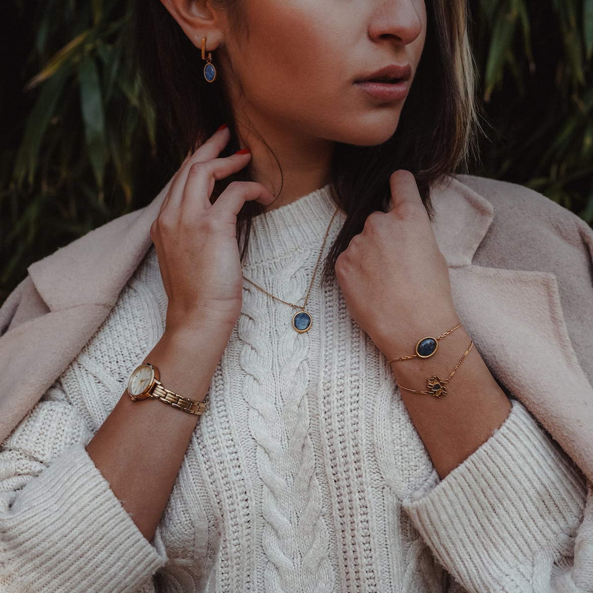 "Mirror Bracelet", elegant bracelet in gold with lapis lazuli, showcased in a stylish, cozy ensemble.
