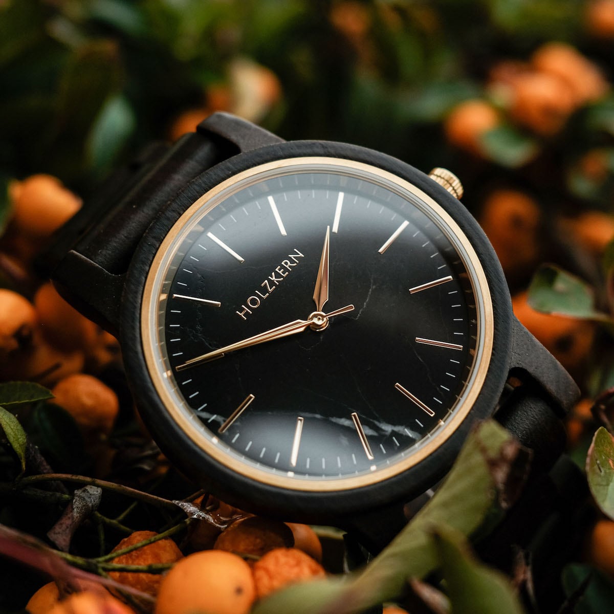 "Summer Night" watch featuring a sleek maple and marble design, surrounded by vibrant foliage.