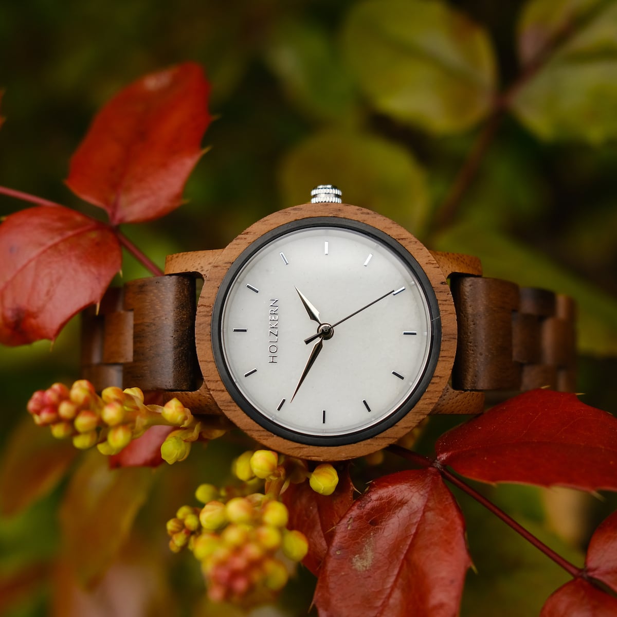 "Air" watch, featuring a walnut wood and marble design, elegantly set against a backdrop of vibrant autumn leaves.