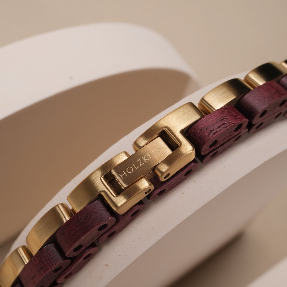 "Duet" bracelet featuring an amaranth and gold design with sleek, modern left.
