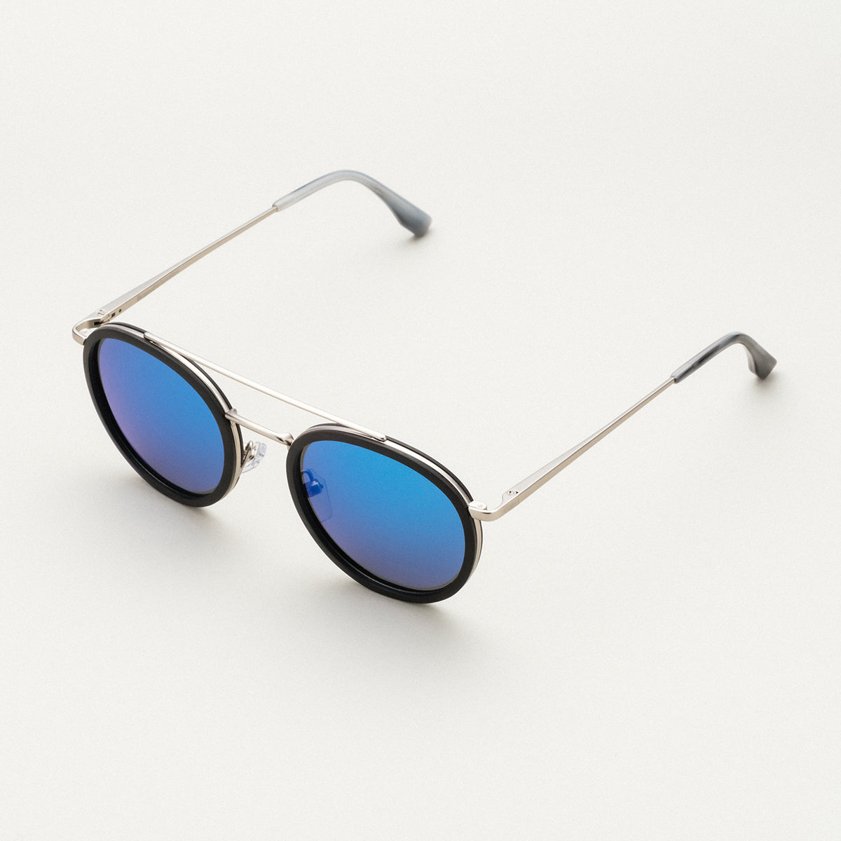 "The Enchanting" sunglasses, circular blue lenses, leadwood frame, and antique silver accents.
