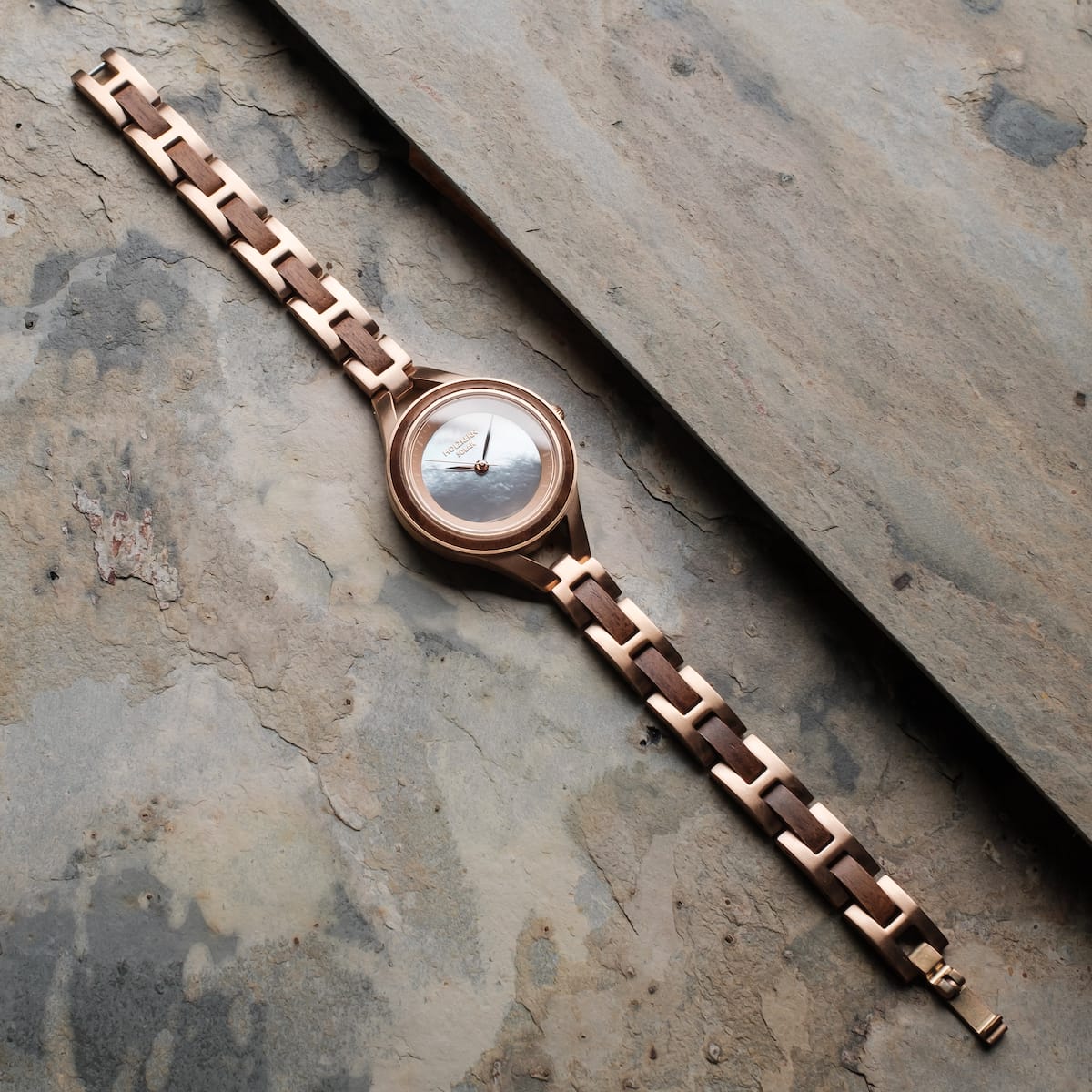 "Fatima" watch featuring a walnut and nacre finish with an elegant chain-link strap design.