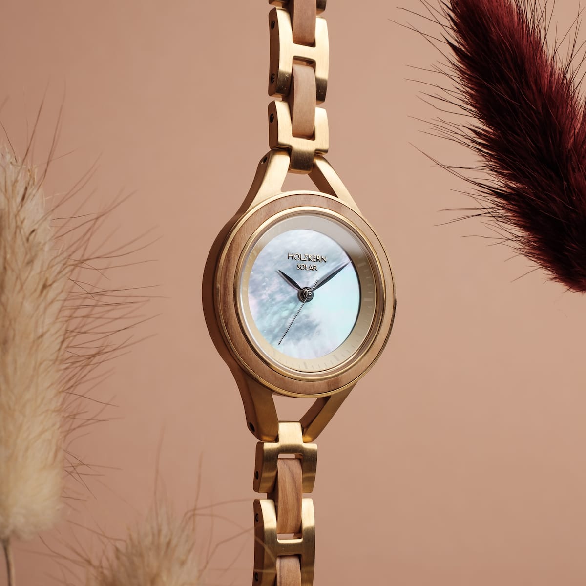 "Tumi" watch in olive and nacre, featuring a sleek and elegant design with a natural aesthetic.