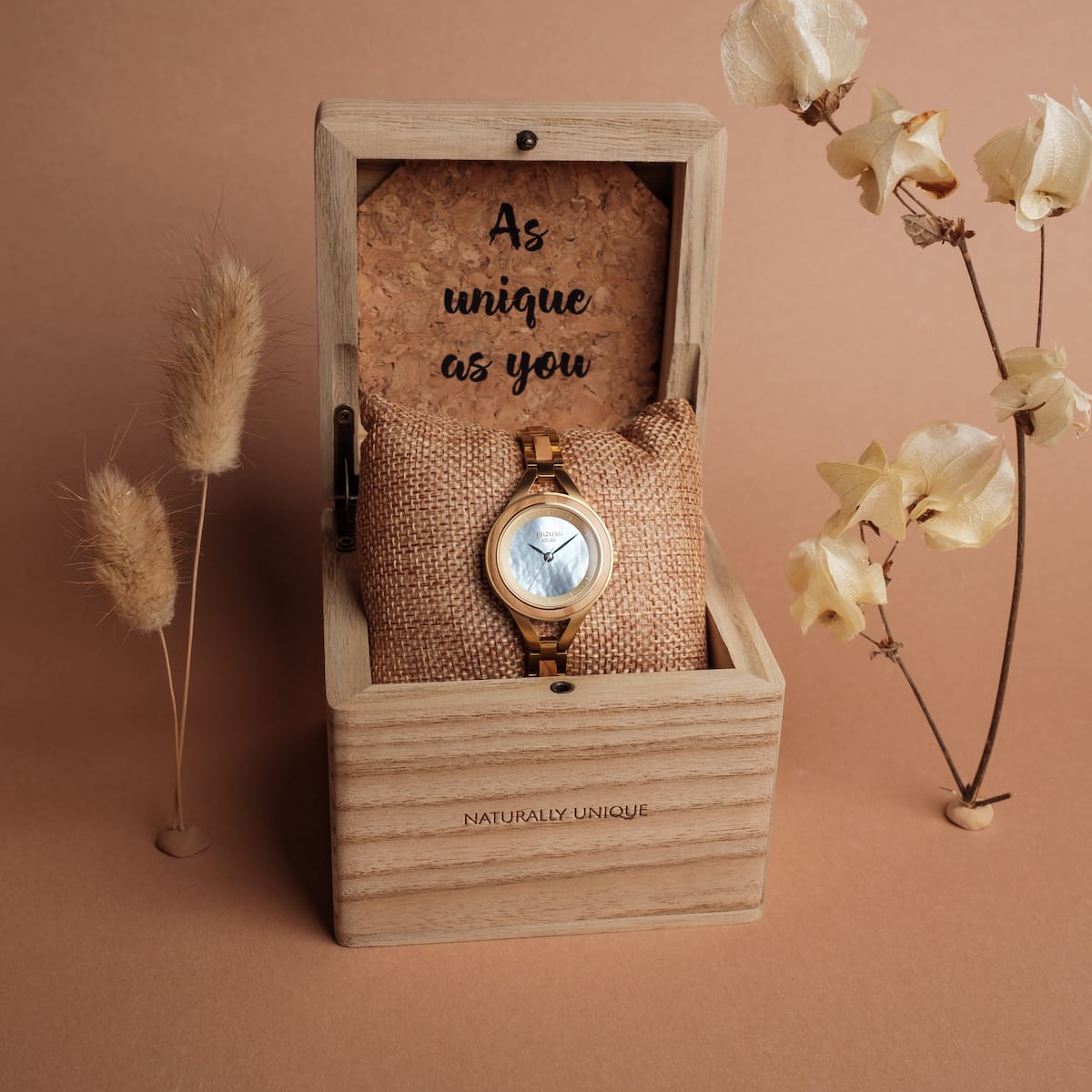 "Tumi" watch in olive/nacre with a natural, rustic display box and elegant floral accents.