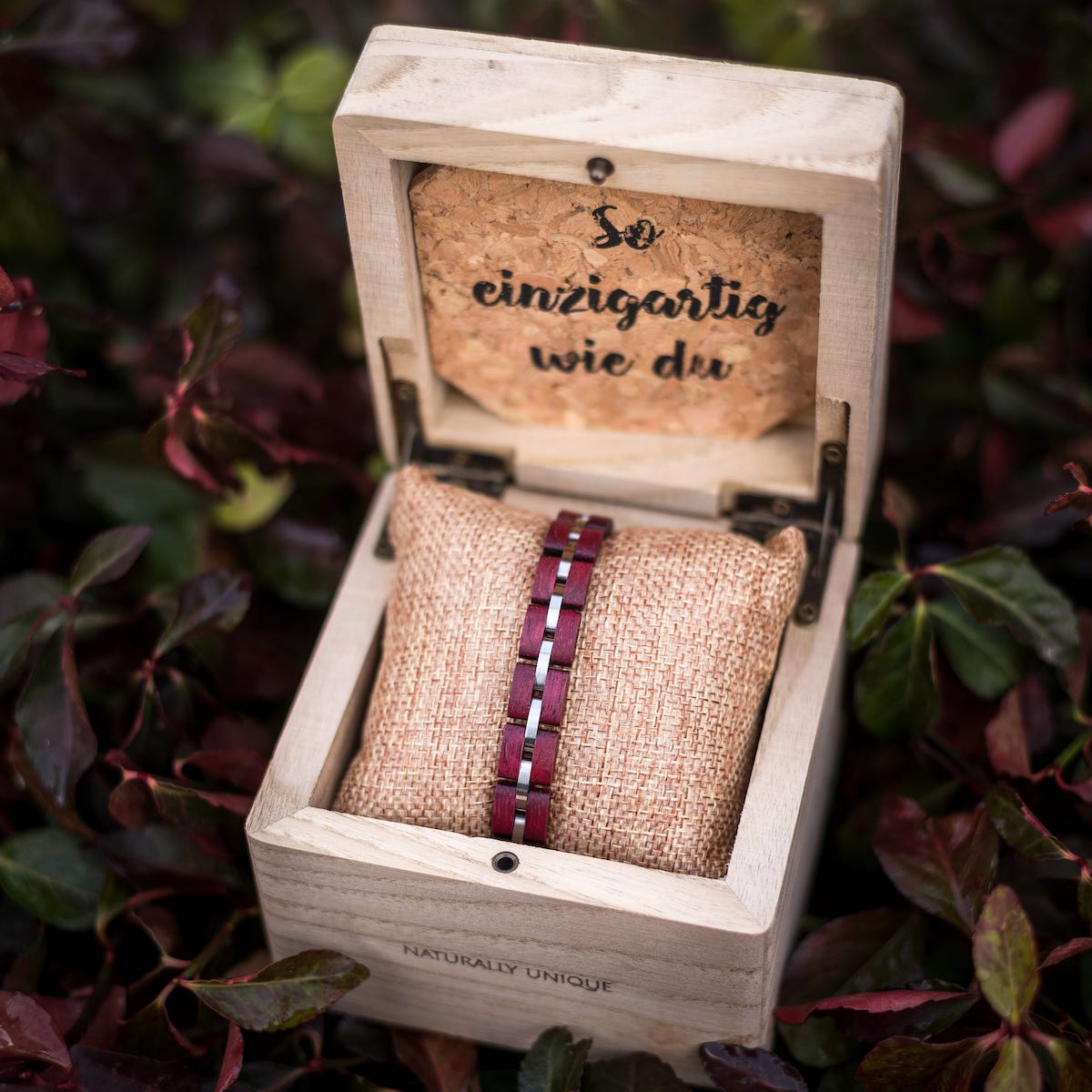 "Fantasia" bracelet in amaranth and silver, elegantly displayed in an open wooden box.
