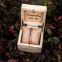 "Fantasia" bracelet features an olivewood and blue design in a rustic, cushioned wooden box.