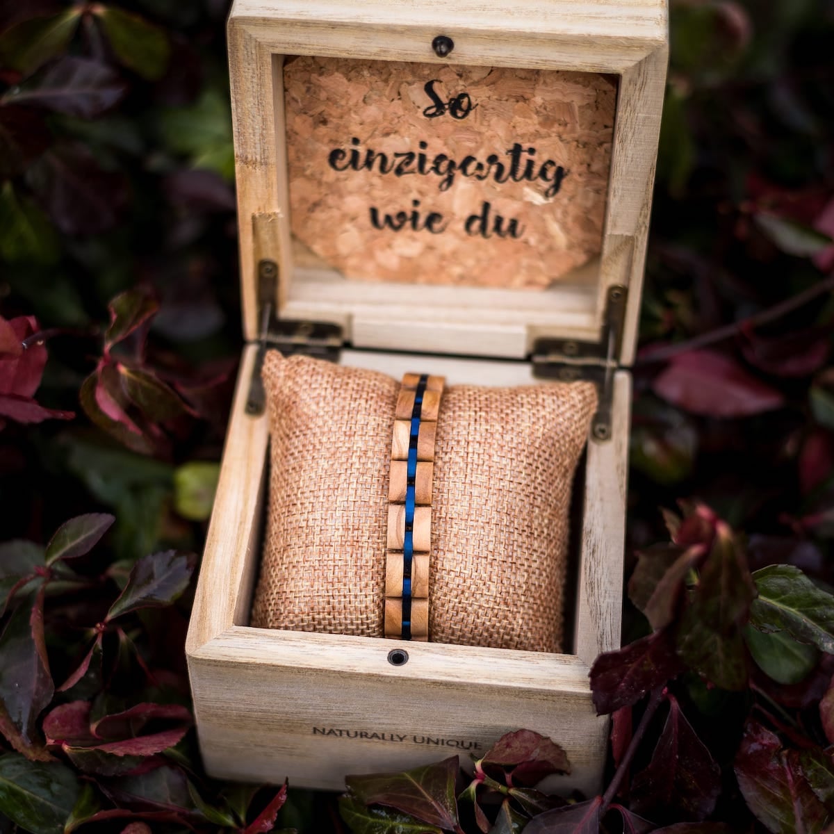 "Fantasia" bracelet, crafted from olivewood and blue accents, elegantly displayed in a rustic wooden box.