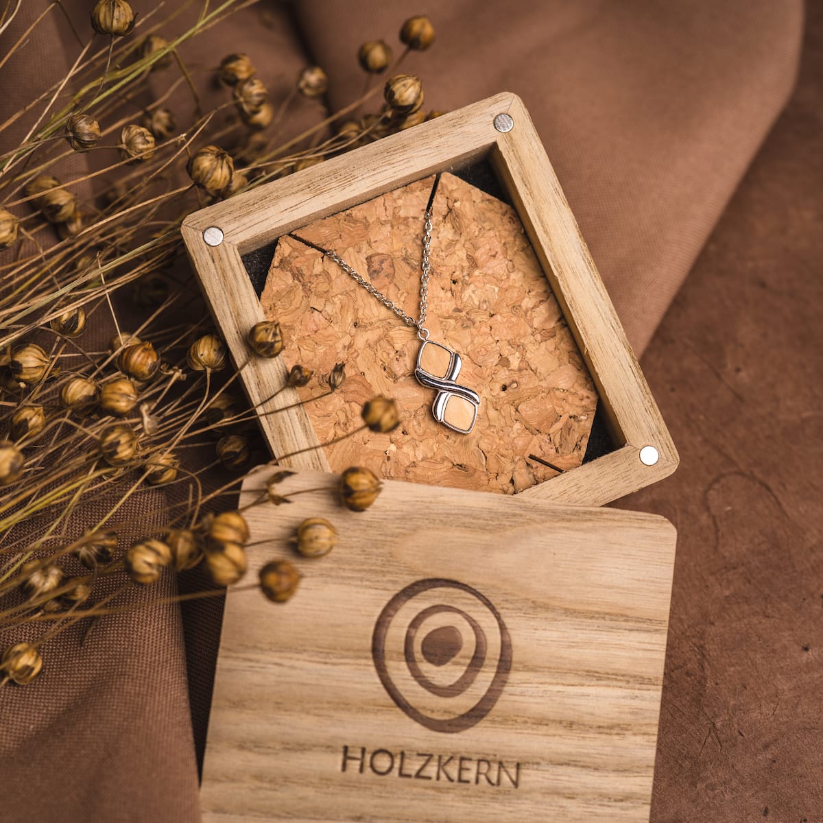 "Mosaic Necklace" necklace, featuring olive and silver accents, elegantly displayed in a wooden box.