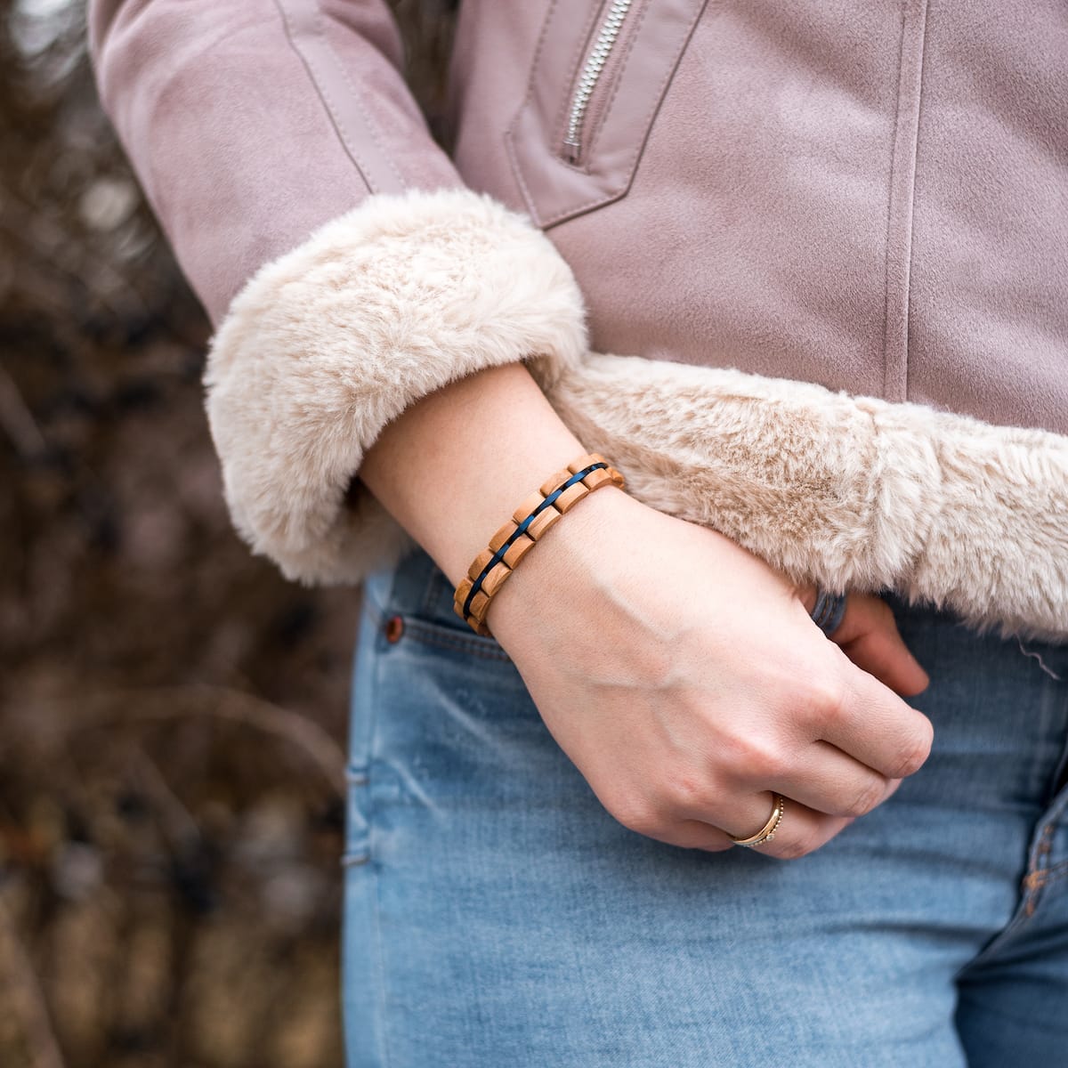 "Fantasia" bracelet featuring olivewood and blue accents, styled elegantly on a wrist.