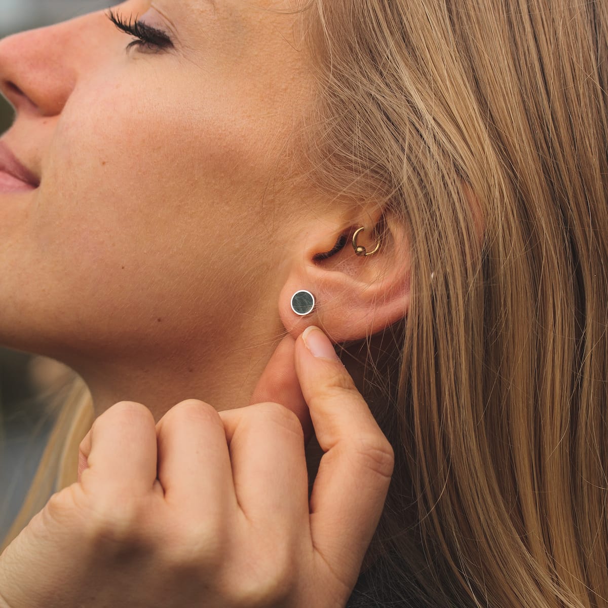 "Concentric earrings", featuring a marble and silver concentric design, worn close-up.