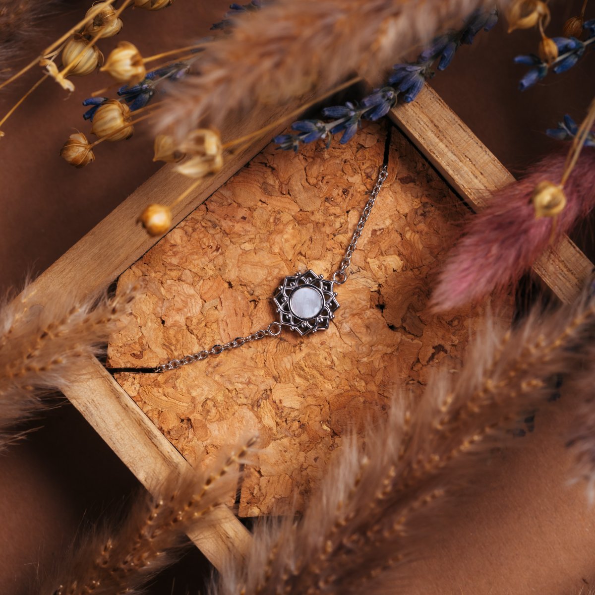 "Composition Bracelet", an elegant bracelet featuring white nacre and silver, styled in a natural and rustic setting.