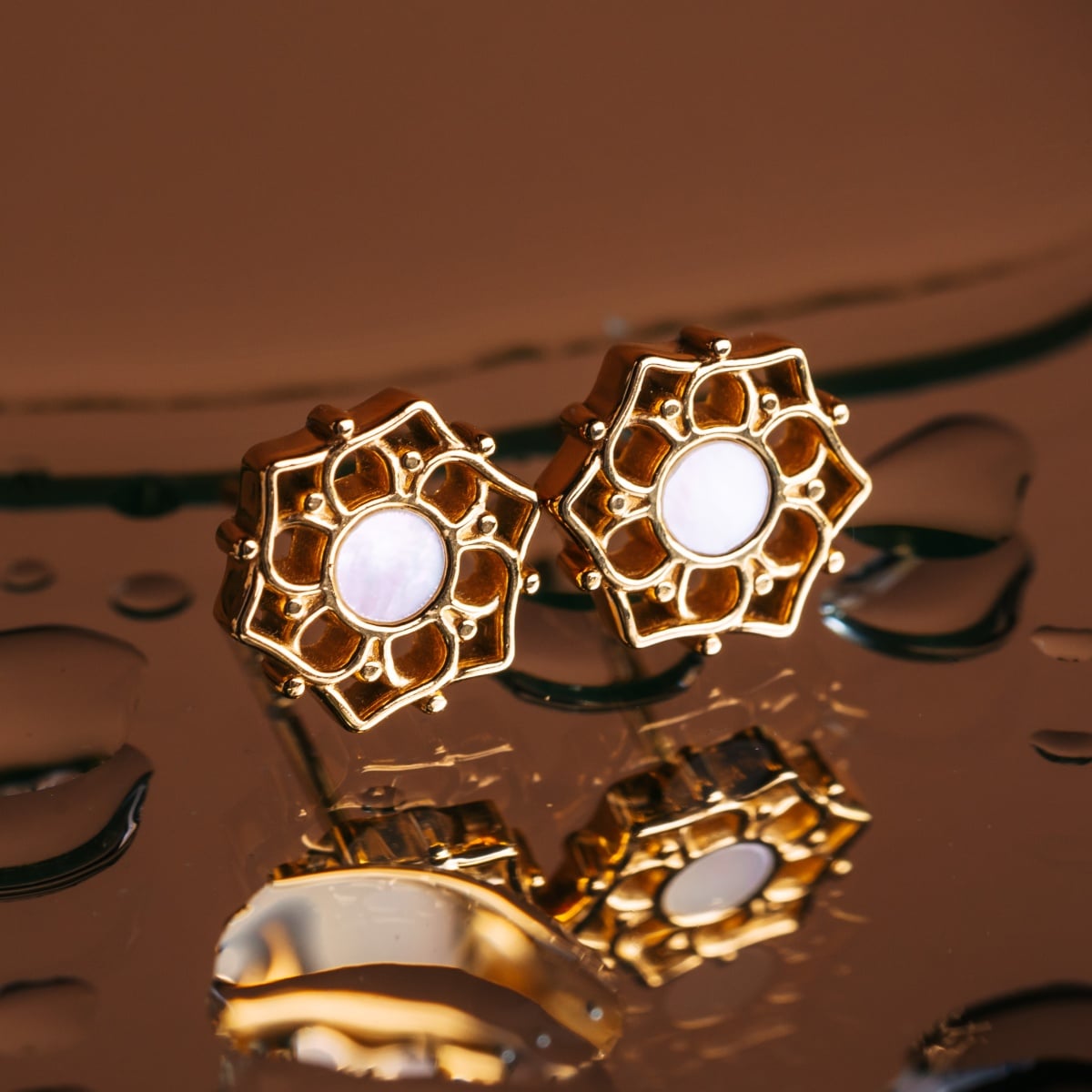 "Composition Earrings": Elegant gold earrings with white nacre, featuring a floral geometric design.