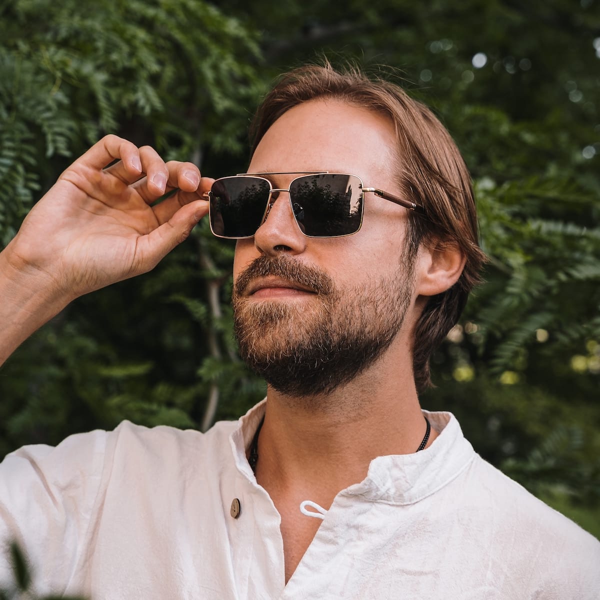 "The Talisman" sunglasses with a walnut and matte gold finish, showcasing a stylish and refined look.