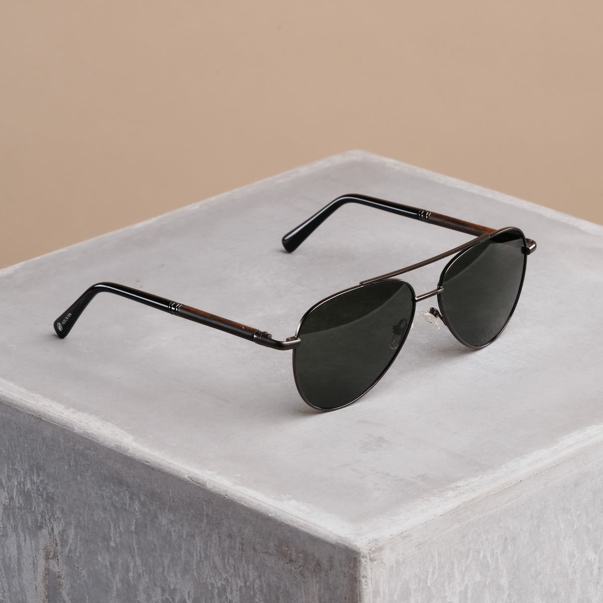 "The Badass II" sunglasses featuring a Leadwood frame and Antique Silver accents on a minimalist backdrop.