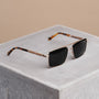 "The Talisman" sunglasses featuring a sleek walnut and matte gold design.