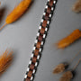 "Triad", a stylish bracelet with walnut wood and silver links, set against a textured background with autumnal accents.