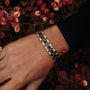 "Triad" bracelet featuring a modern design with walnut and silver tones.